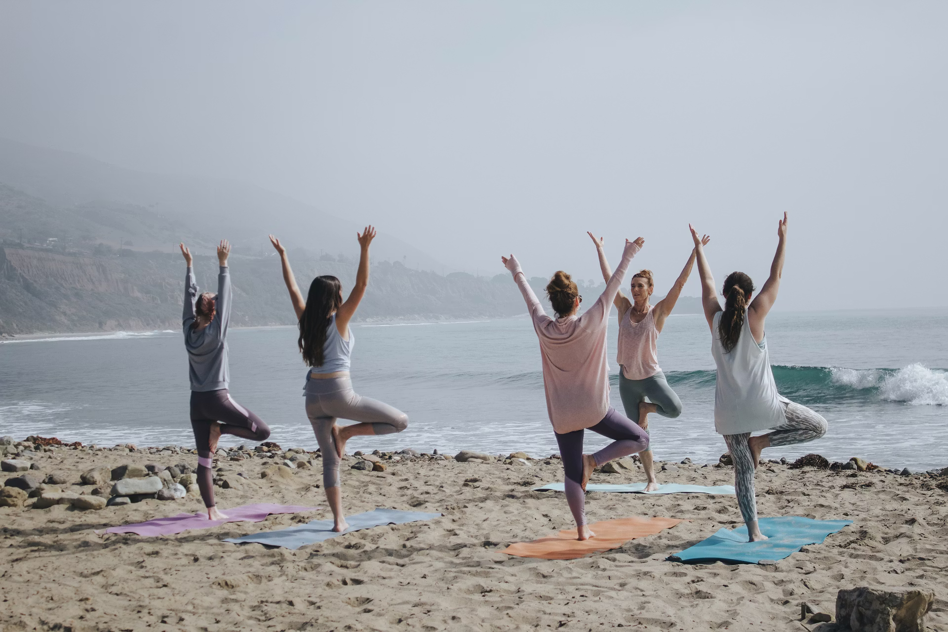 5 woman on the beach doing yoga